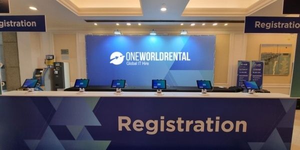 Ruime registratiebalie met schermen en bewegwijzering voor een congres