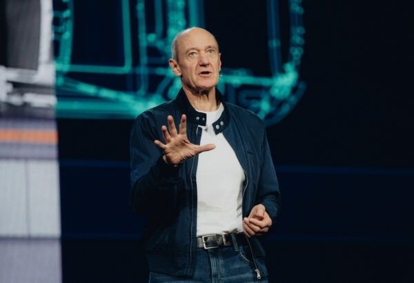 Spreker op een verlicht hoofdpodium tijdens een keynote-presentatie